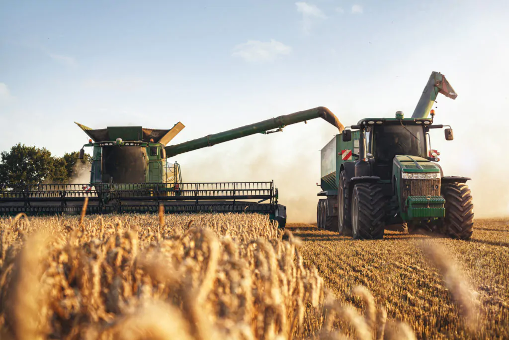 tractors and combine harvester harvesting on a farm